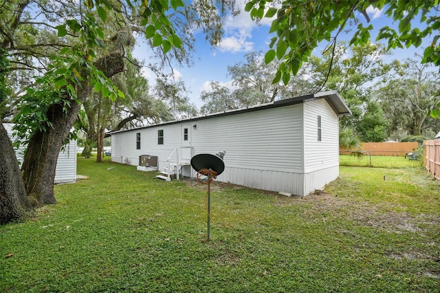 4611 Gall Blvd, Zephyrhills, FL 33542 - rear view of property with fence, cooling unit, and a lawn