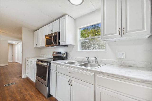 4611 Gall Blvd, Zephyrhills, FL 33542 - kitchen with visible vents, a sink, dark wood-type flooring, stainless steel appliances, and white cabinets