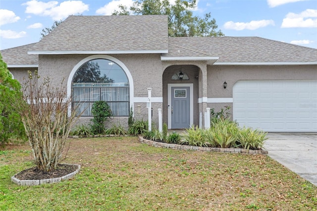 ranch-style house featuring a front yard and a garage