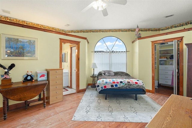 bedroom with connected bathroom, light hardwood / wood-style floors, and ceiling fan