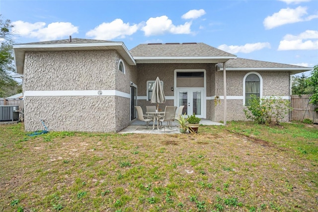 back of property with a yard, french doors, a patio, and central AC unit