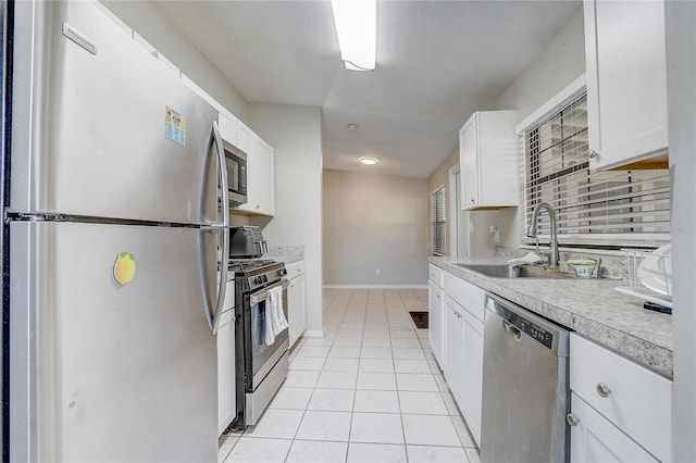 kitchen with sink, white cabinets, light tile patterned floors, and appliances with stainless steel finishes