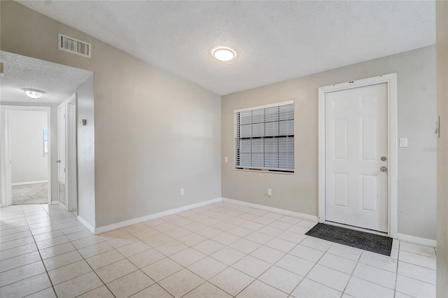 entrance foyer with light tile patterned floors and a textured ceiling