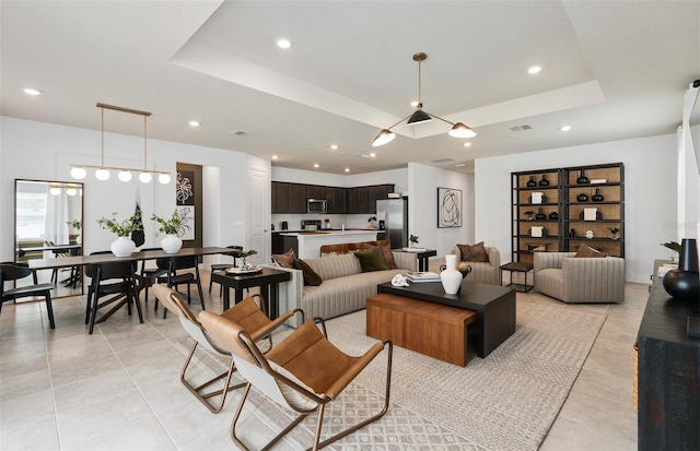 living room with light tile patterned floors and a tray ceiling