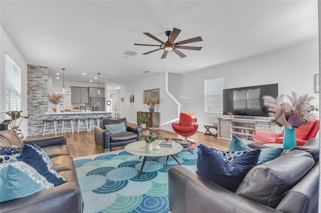 living room featuring light hardwood / wood-style flooring and ceiling fan