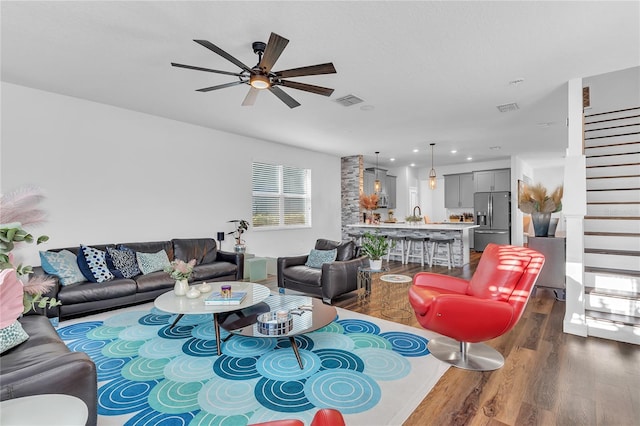 living room featuring dark hardwood / wood-style floors, ceiling fan, and sink