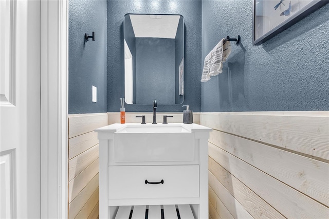 bathroom featuring vanity and wooden walls