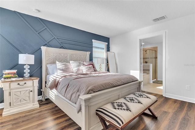 bedroom featuring dark hardwood / wood-style flooring and ensuite bath