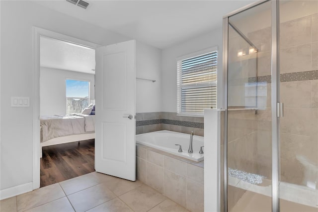 bathroom featuring tile patterned flooring, plenty of natural light, and plus walk in shower