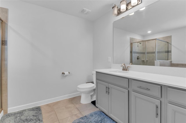 bathroom with tile patterned floors, toilet, vanity, and walk in shower