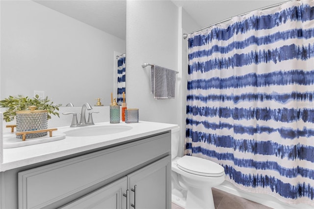 bathroom featuring a shower with shower curtain, vanity, toilet, and tile patterned flooring