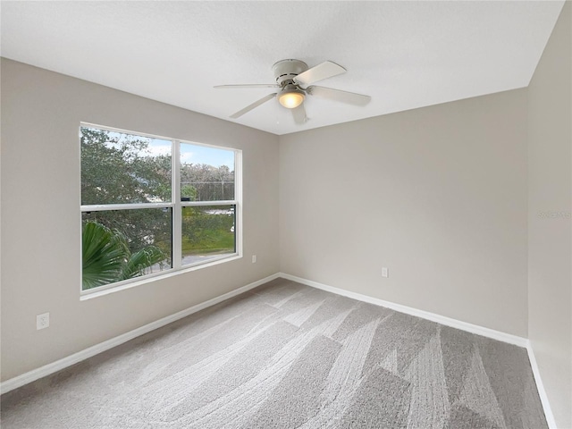 carpeted spare room with ceiling fan