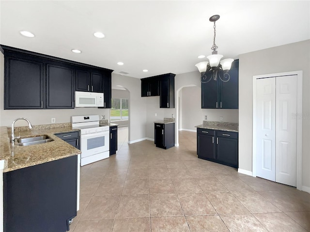 kitchen featuring white appliances, sink, pendant lighting, light tile patterned floors, and a chandelier