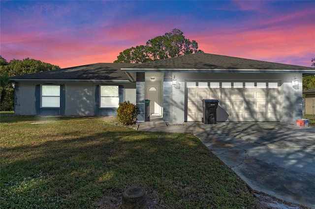 view of front of house with a garage and a lawn