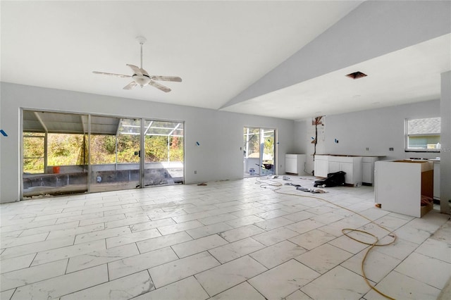 unfurnished living room with ceiling fan, washer / dryer, and lofted ceiling