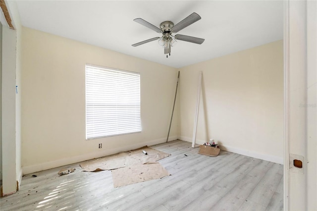 empty room with ceiling fan and light hardwood / wood-style flooring