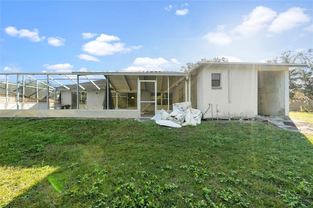 back of property with a lanai and a lawn