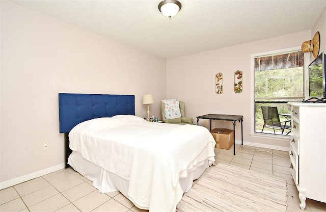 bedroom with a textured ceiling and light tile patterned flooring