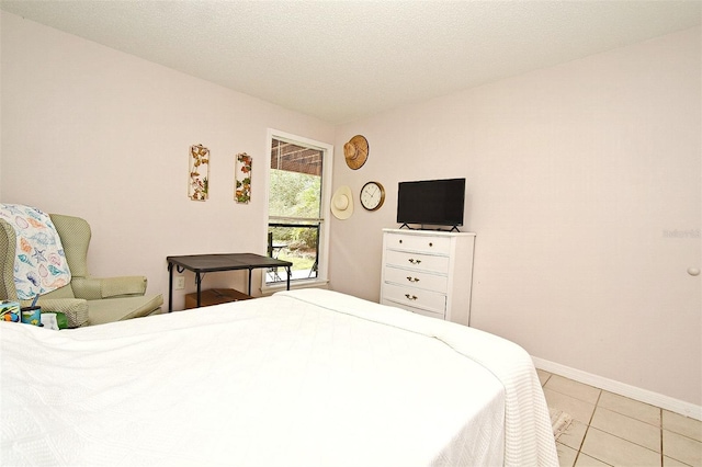 bedroom featuring light tile patterned floors and a textured ceiling