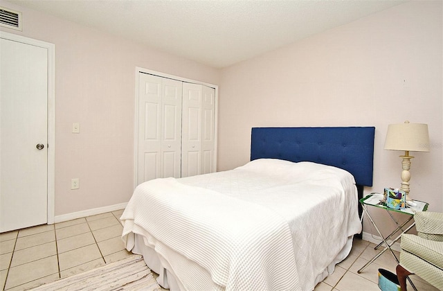 bedroom with light tile patterned floors and a closet