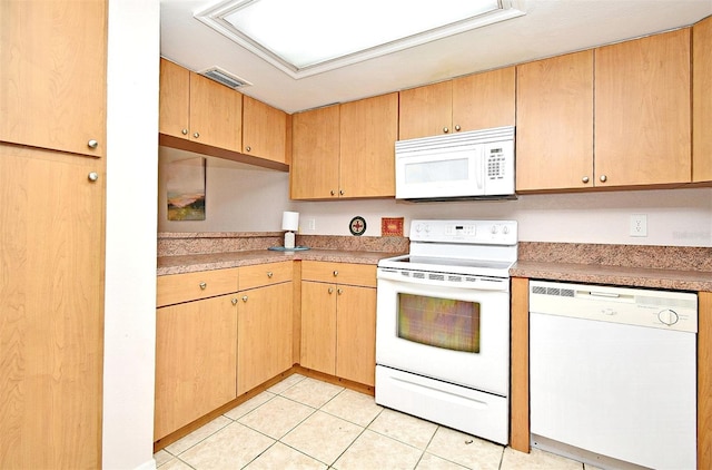 kitchen featuring light tile patterned flooring and white appliances