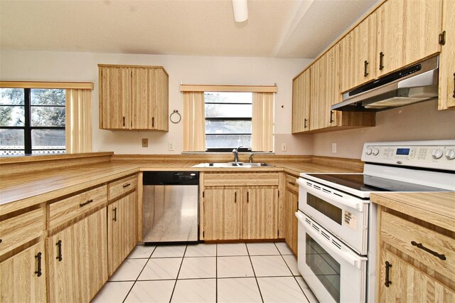 kitchen featuring sink, light brown cabinets, light tile patterned floors, dishwasher, and white electric range