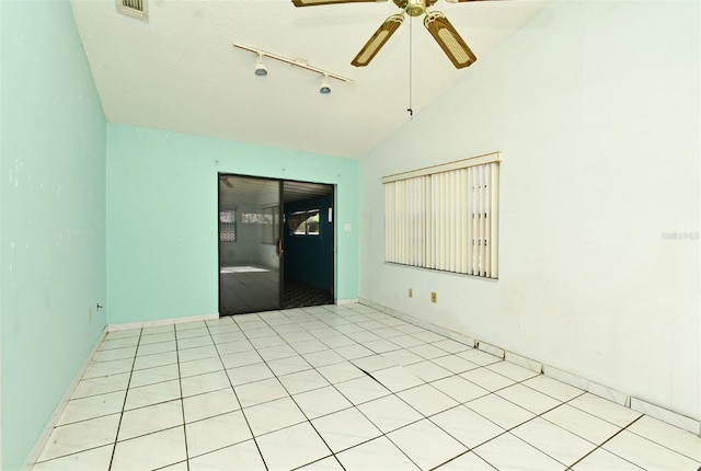 tiled spare room with a textured ceiling, ceiling fan, rail lighting, and lofted ceiling