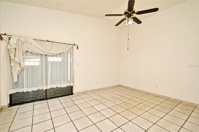 empty room featuring ceiling fan, light tile patterned flooring, and vaulted ceiling