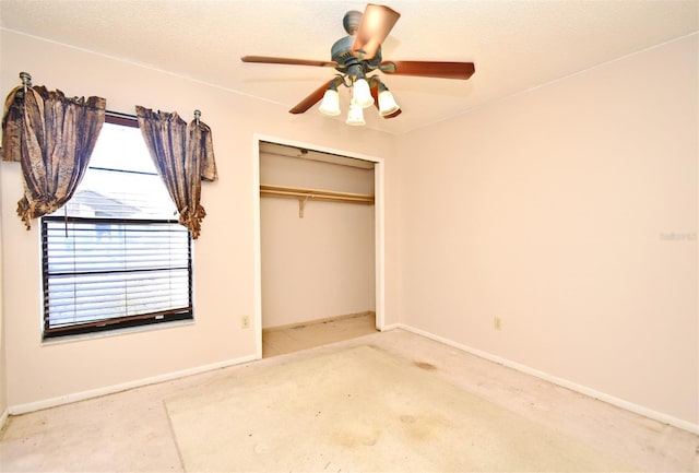 unfurnished bedroom with ceiling fan and a closet