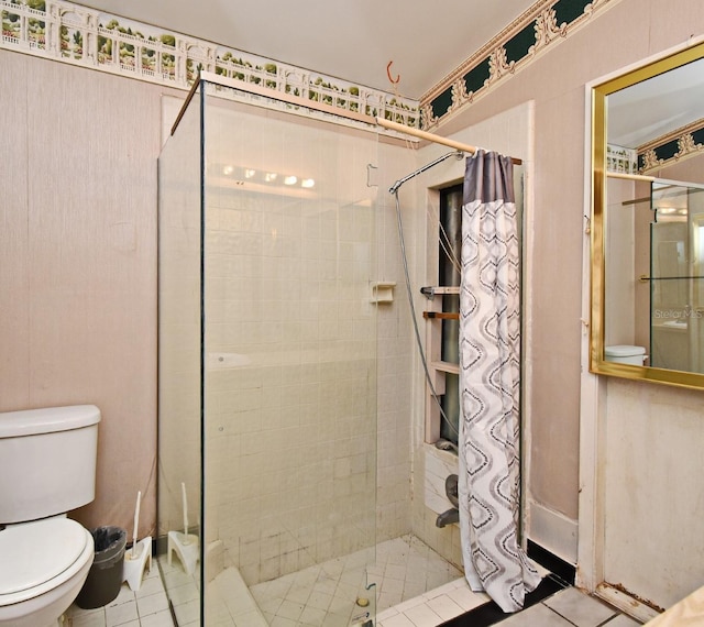 bathroom featuring tile patterned flooring, toilet, and curtained shower