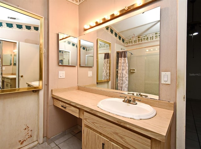 bathroom with tile patterned flooring, vanity, and curtained shower