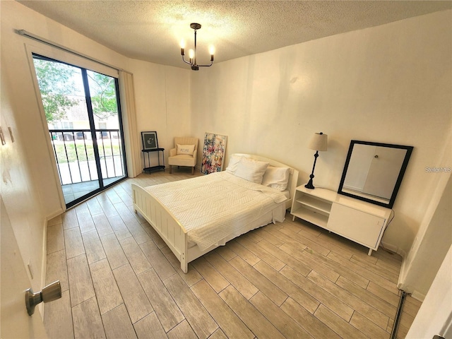 bedroom with access to exterior, a textured ceiling, and a notable chandelier