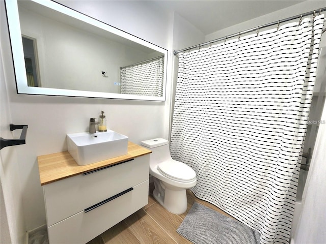 bathroom with hardwood / wood-style flooring, vanity, toilet, and a shower with curtain