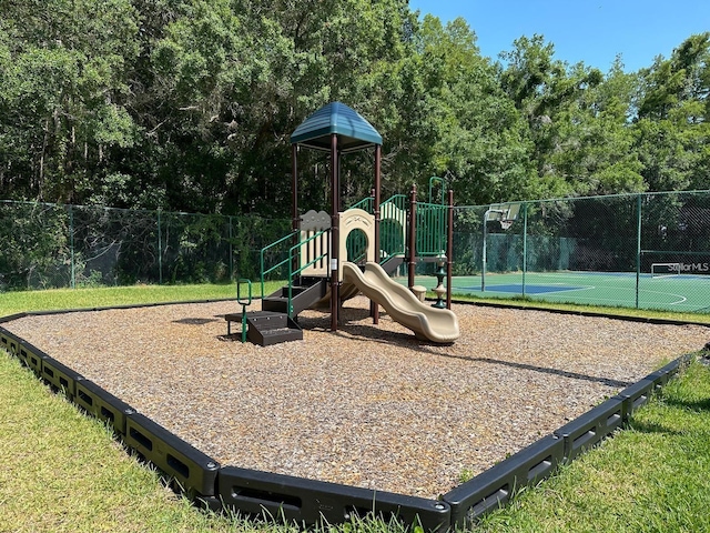 view of jungle gym featuring basketball hoop and tennis court