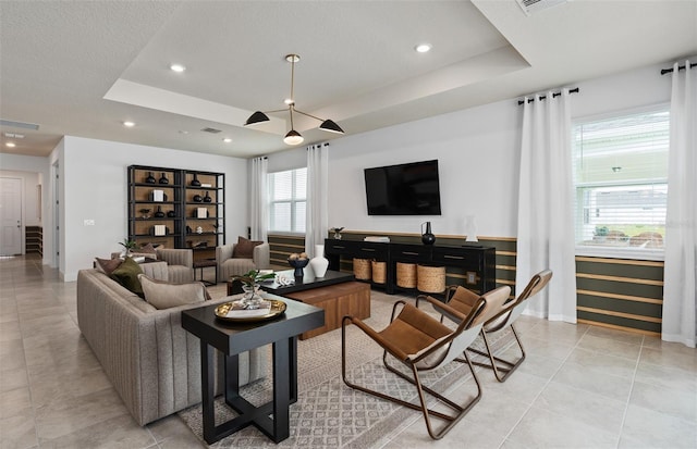 tiled living room featuring a tray ceiling