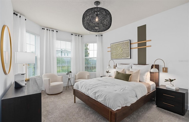 bedroom featuring light colored carpet and multiple windows