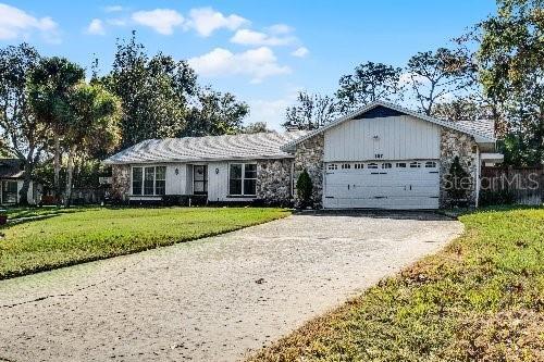 ranch-style home with a garage and a front lawn