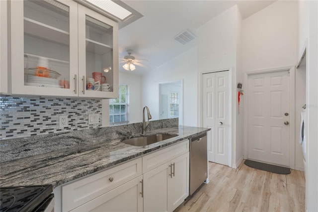 kitchen featuring white cabinets, stone counters, dishwasher, and sink