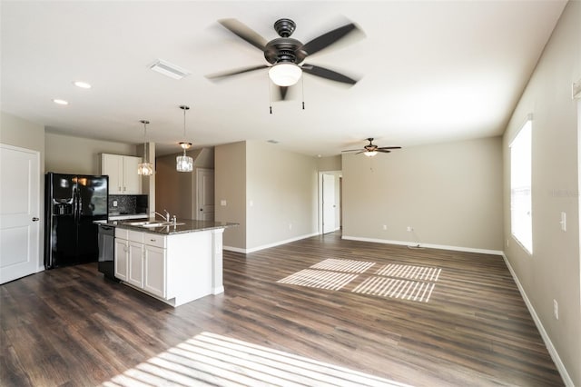 kitchen featuring white cabinets, sink, an island with sink, and black appliances