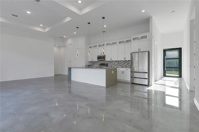 kitchen with white cabinetry, a center island with sink, hanging light fixtures, and appliances with stainless steel finishes