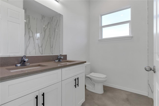 bathroom featuring vanity, concrete floors, and toilet