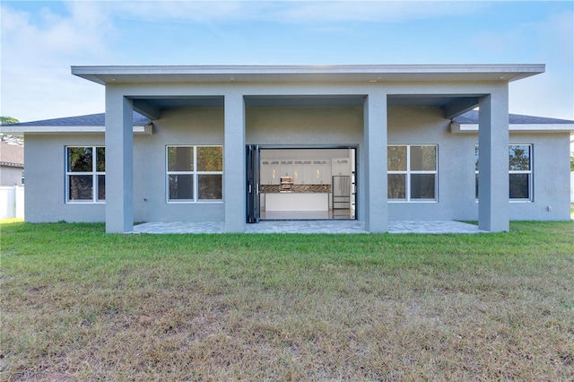 rear view of house featuring a lawn and a patio area