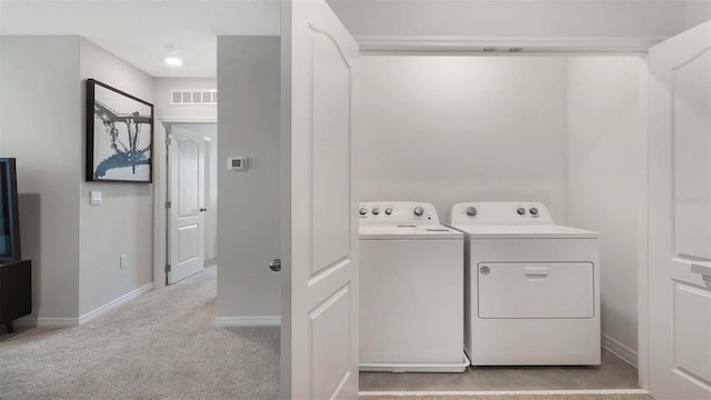 laundry room featuring washing machine and dryer and light carpet