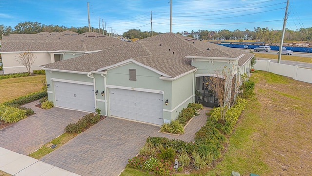 1987 Key Bay Trl, Kissimmee, FL 34747 - view of front of home with stucco siding, decorative driveway, an attached garage, and a shingled roof