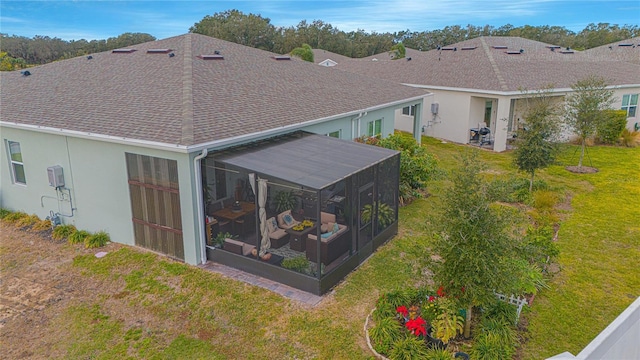 1987 Key Bay Trl, Kissimmee, FL 34747 - back of house featuring a sunroom, roof with shingles, a lawn, and stucco siding