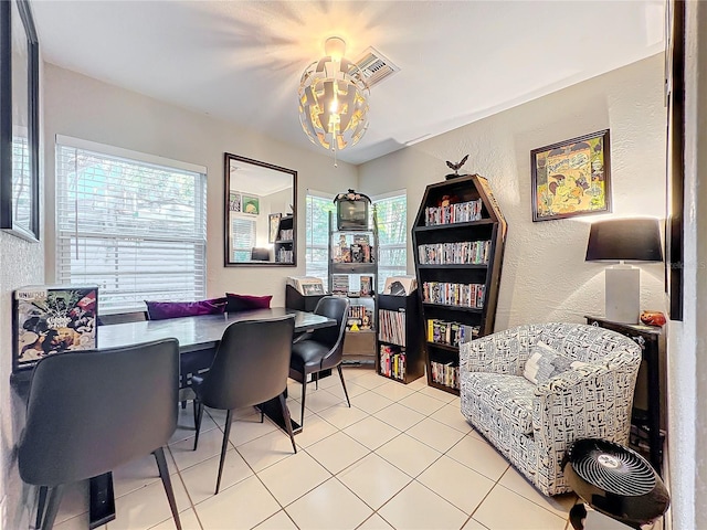 dining area featuring light tile patterned floors and an inviting chandelier