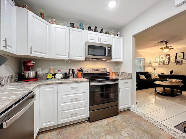 kitchen featuring white cabinets, ceiling fan, light tile patterned flooring, and stainless steel appliances