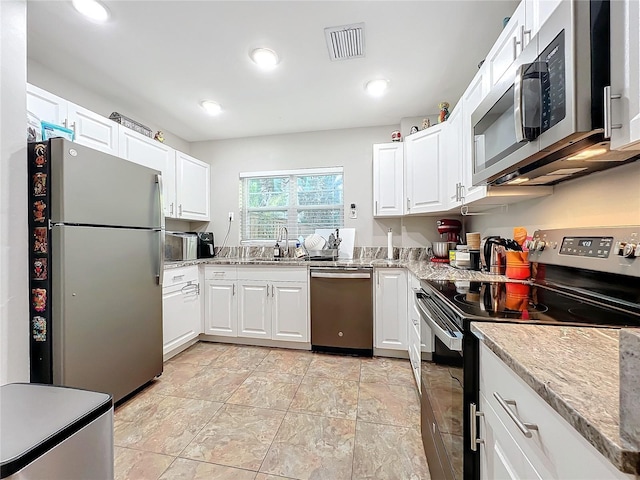 kitchen featuring light stone countertops, white cabinetry, sink, and stainless steel appliances