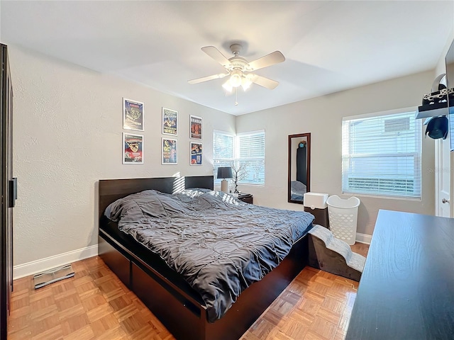 bedroom with multiple windows, light parquet flooring, and ceiling fan