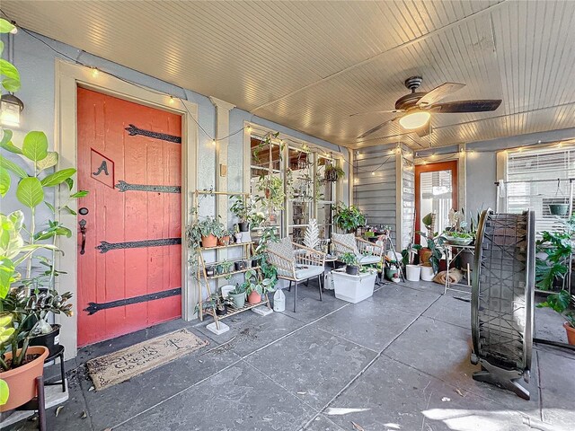 unfurnished sunroom featuring ceiling fan